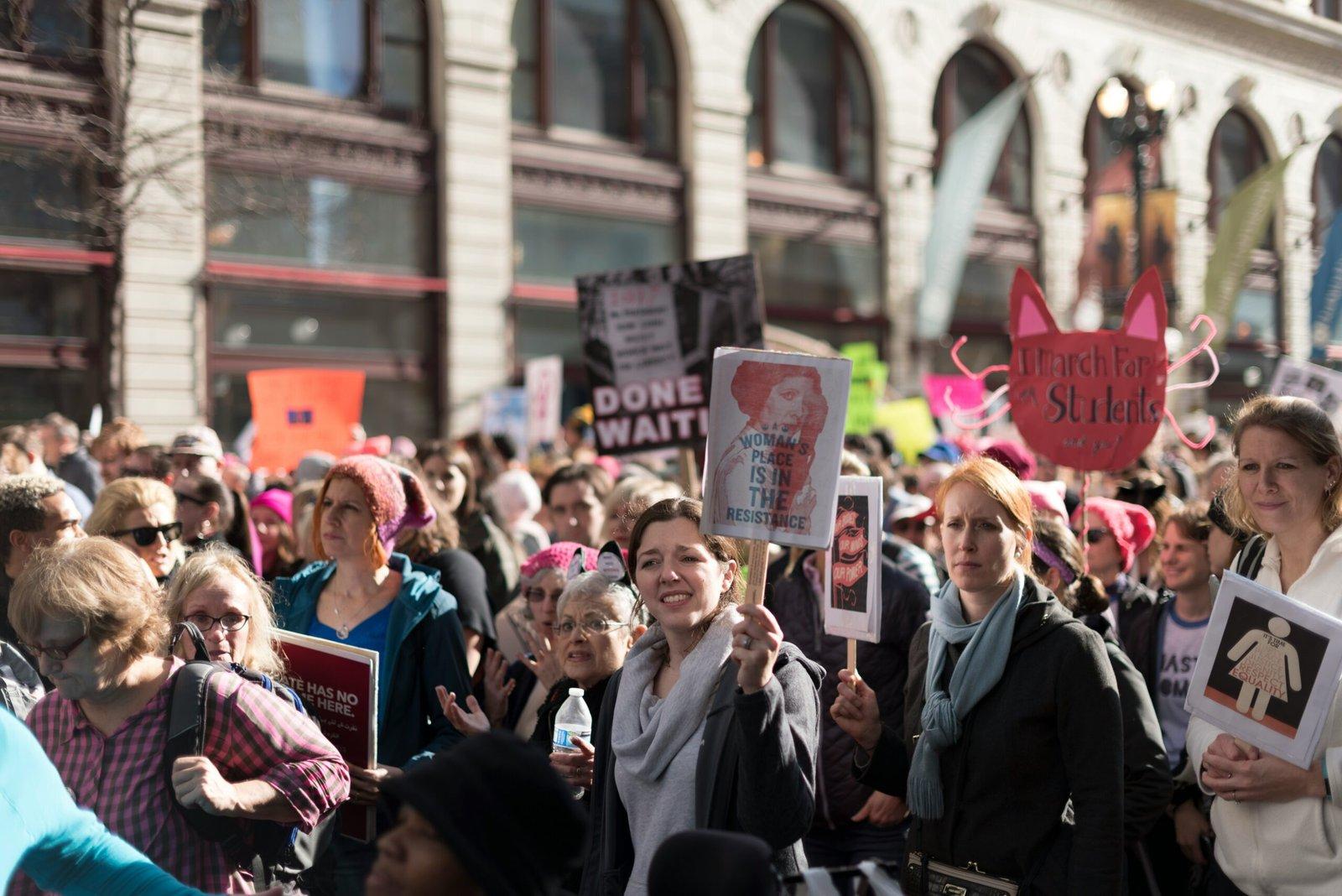 Women in a protest holding signs